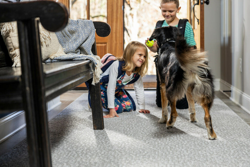 Kids playing with dog on carpet floors | Carpets And More, Inc